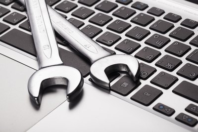 Bits & Bytes - Softwarelösungen kompakt präsentiert Zwei Schraubenschlüssel auf einem Laptop