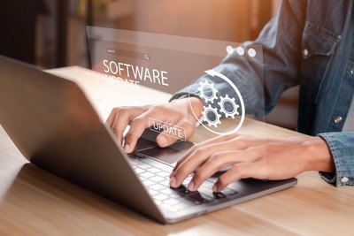 Software Update Mann arbeitet und installiert ein Update auf einem Laptop