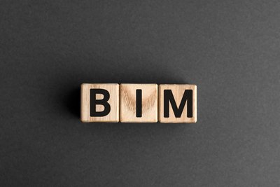 BIM - Building Information Modeling Drei Holzwürfel mit dem Wort BIM auf grauem Hintergrund